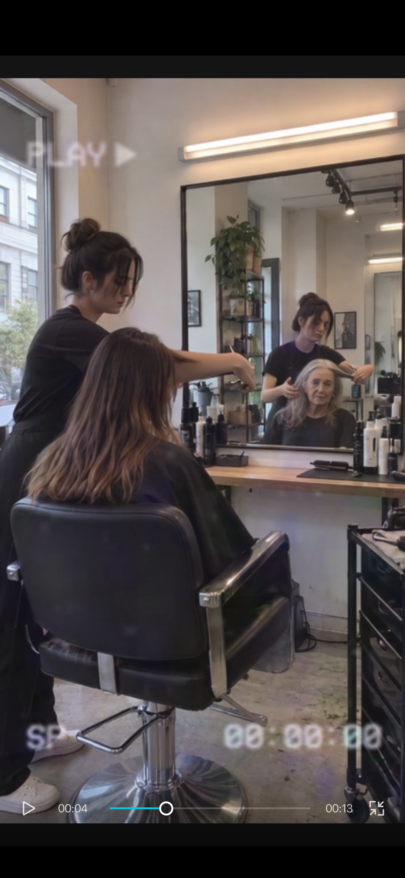 Young client in the physical chair and older-looking woman in the mirror